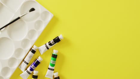 video de pantalones, pincel y paleta con espacio de copia en fondo amarillo