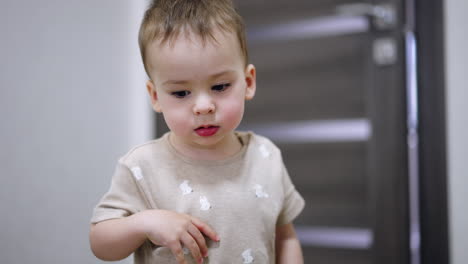 thoughtful little boy stands at the camera. kid opens the door and runs away from the room.