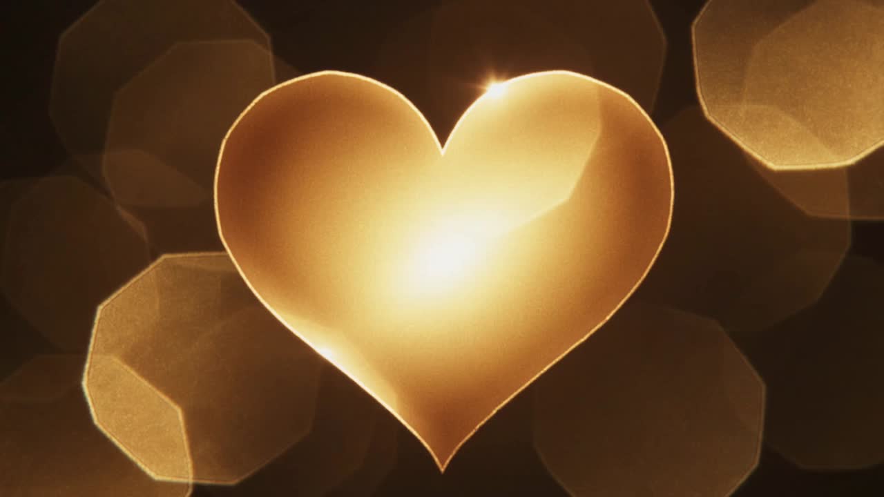 Cuore dorato scintillante che mostra la spazzata luminosa dopo l'impulso di luce su un palco buio con bokeh scintillante