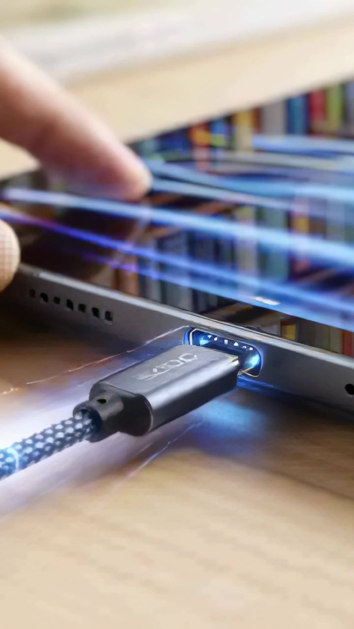 Vertical video: Guiding braided USB-C plug into tablet port at desk, user tapping screen, charging