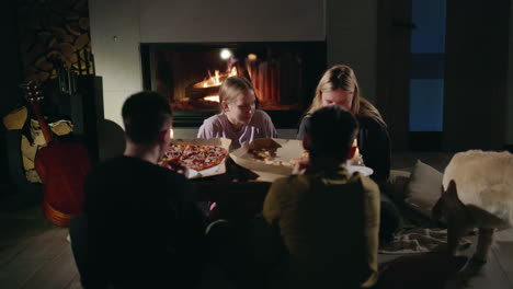 friends enjoying pizza by the fireplace