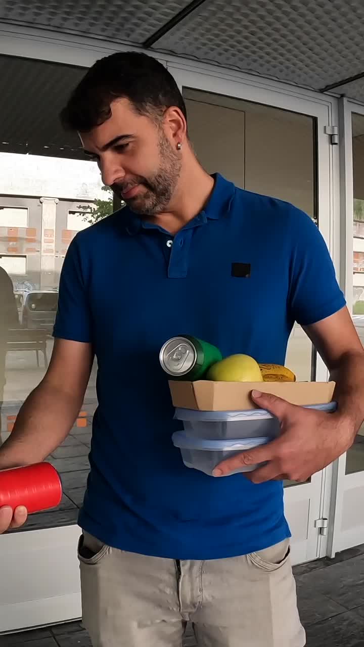 A man holding a tray with food and cans