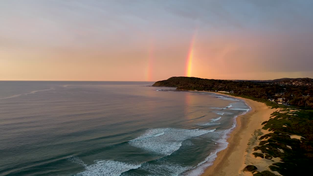 Aerial drone landscape shot of double rainbow over scenic beach shot Shelly Beach travel tourism NSW Central Coast Australia 4K