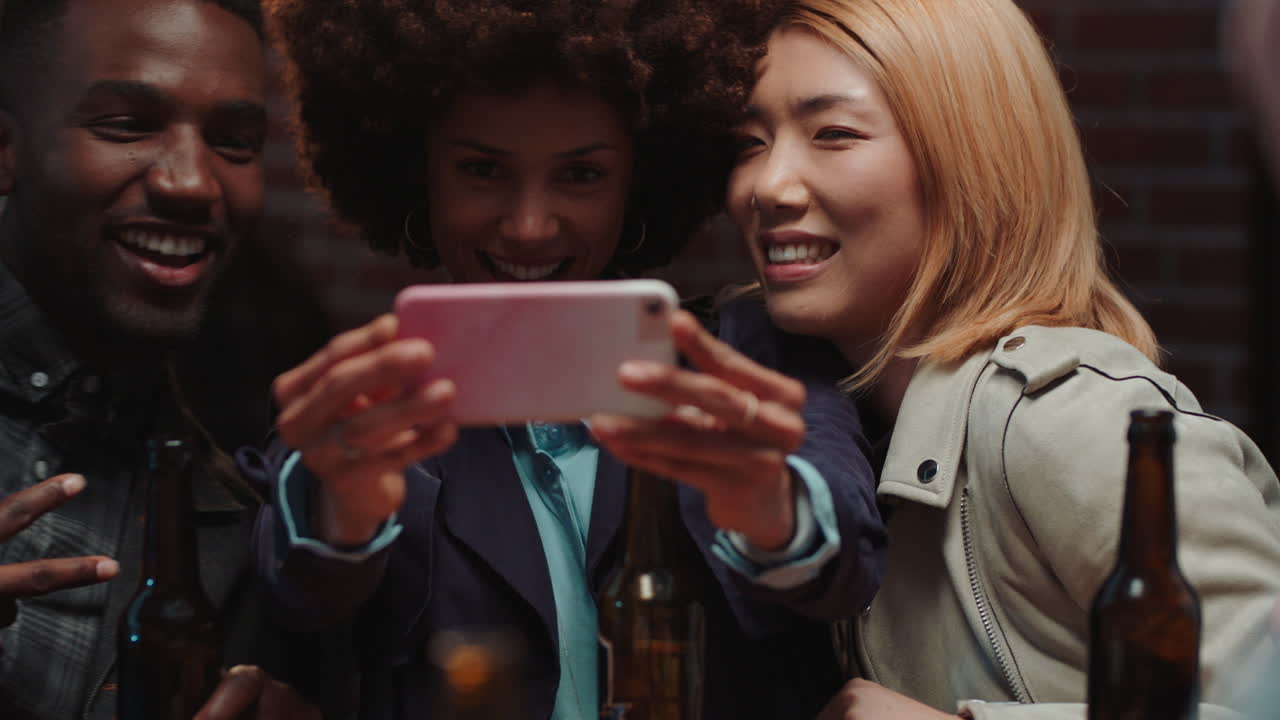 amigos felices posando para la foto usando teléfonos inteligentes celebrando compartiendo fiesta de celebración en las redes sociales disfrutando haciendo recuerdos juntos