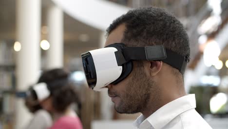 cheerful african american user wearing vr glasses at the library