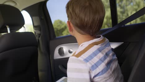 handheld video of boy with tablet during a road trip