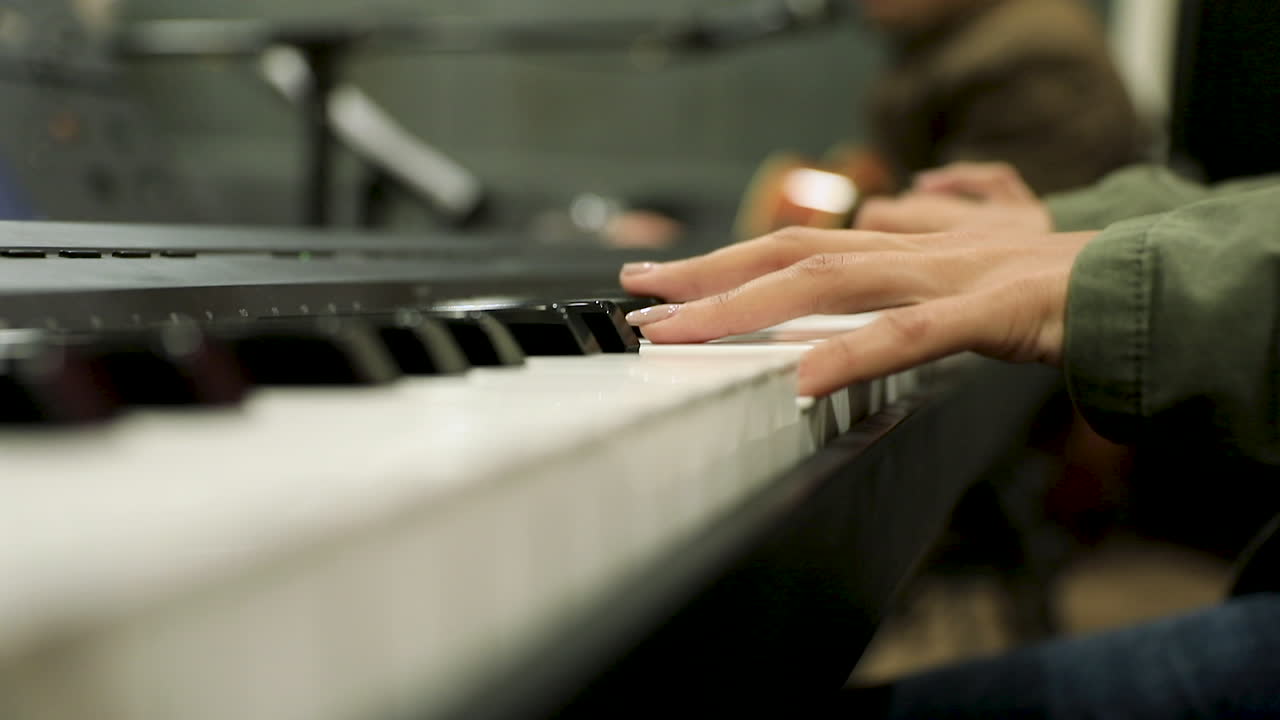 Female hands playing the piano in the studio