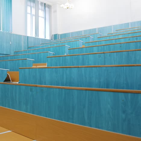 modern auditorium with wooden desks without people. large meeting hall with empty desks. nobody in lecture hall in the university during quarantine