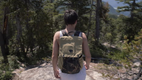 man with backpack walking down the hill in canadian wilderness