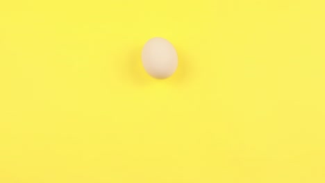 on a yellow background, four white chicken eggs