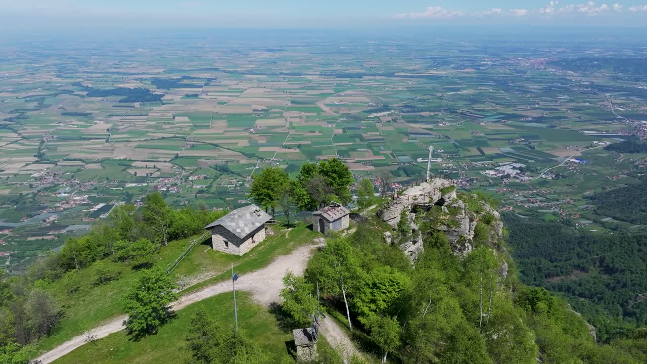 Bird’s eye drone view of Croce di Envie, also known as Cima Bracco, the highest point of Mombracco mountain in the Cottian Alps, Piemonte, Italy, featuring its summit cross and alpine scenery