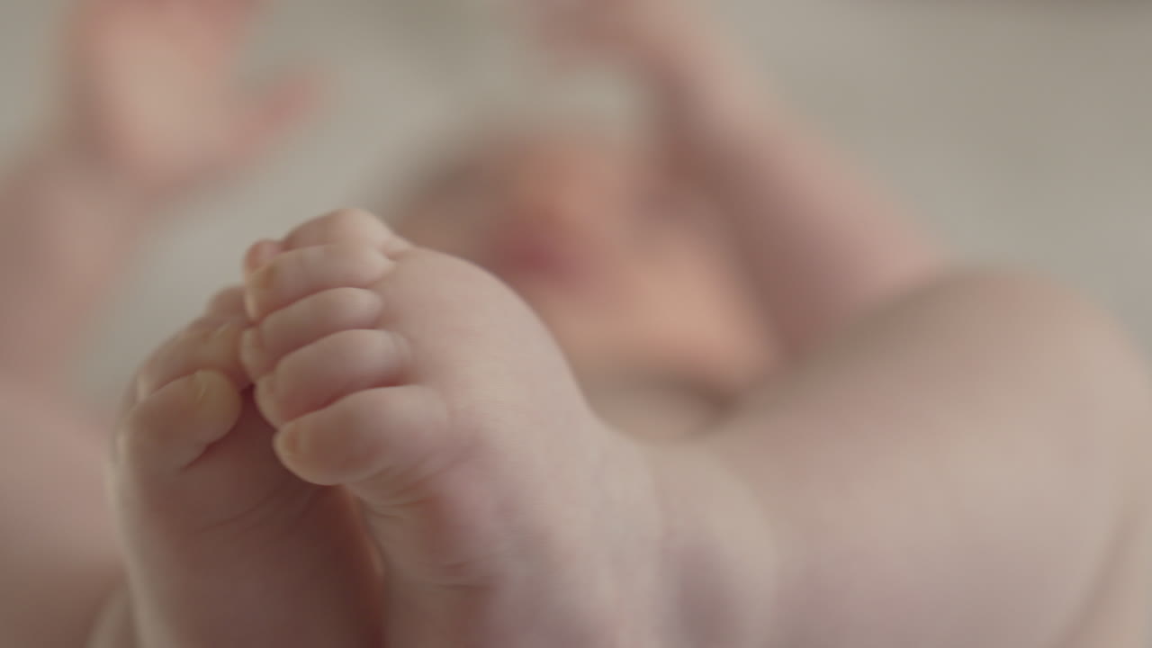 Primo piano adorabile di piedini e ditina di un bambino caucasico, macro 4k di un neonato giocoso