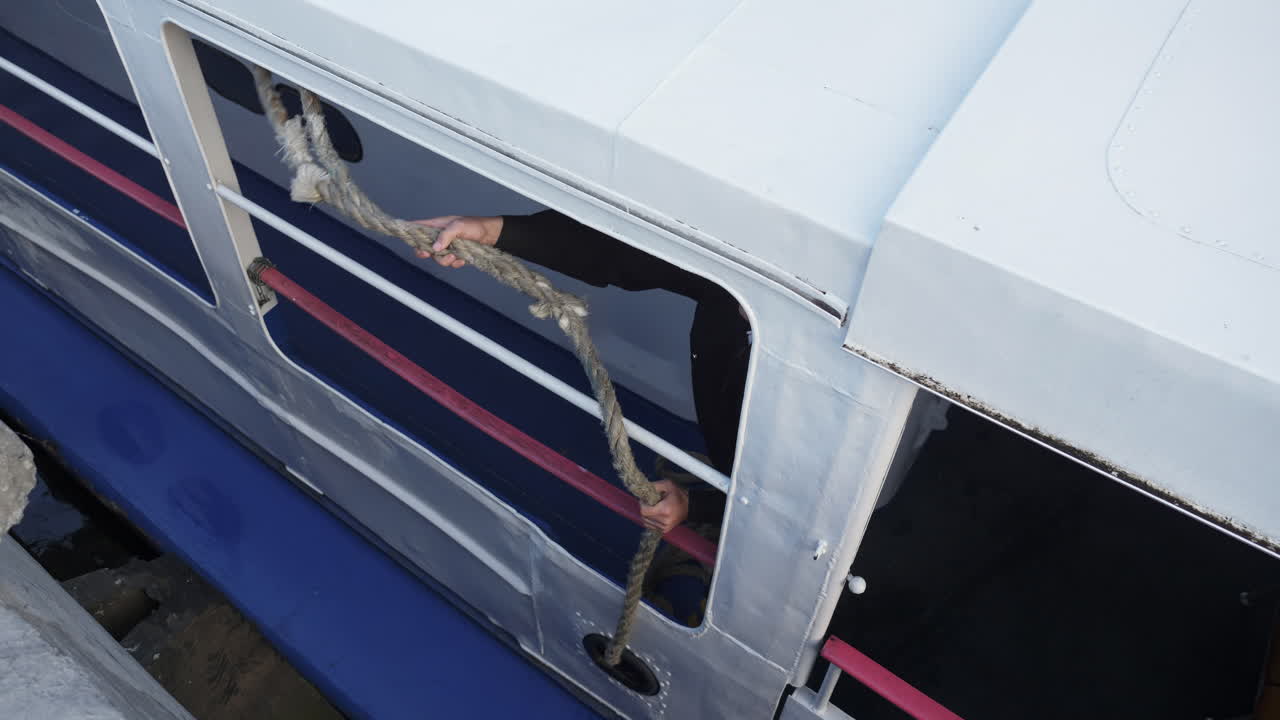 Crew member handling a mooring rope on a boat