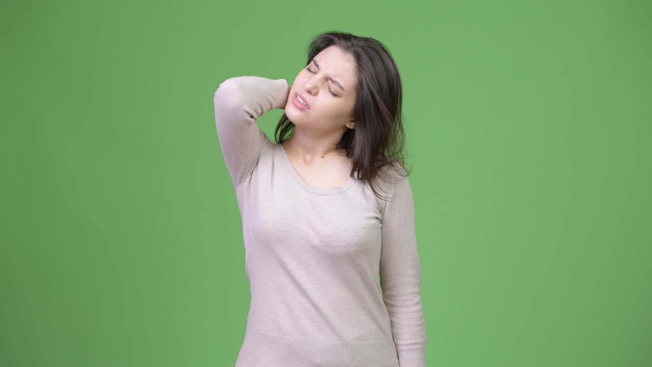 首の痛みを抱えている、疲れた若い女性。
