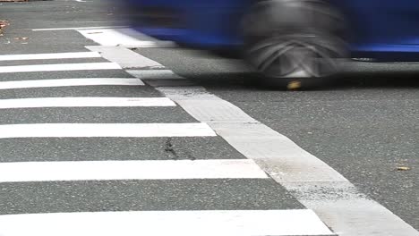 cars driving over a crosswalk at an intersection