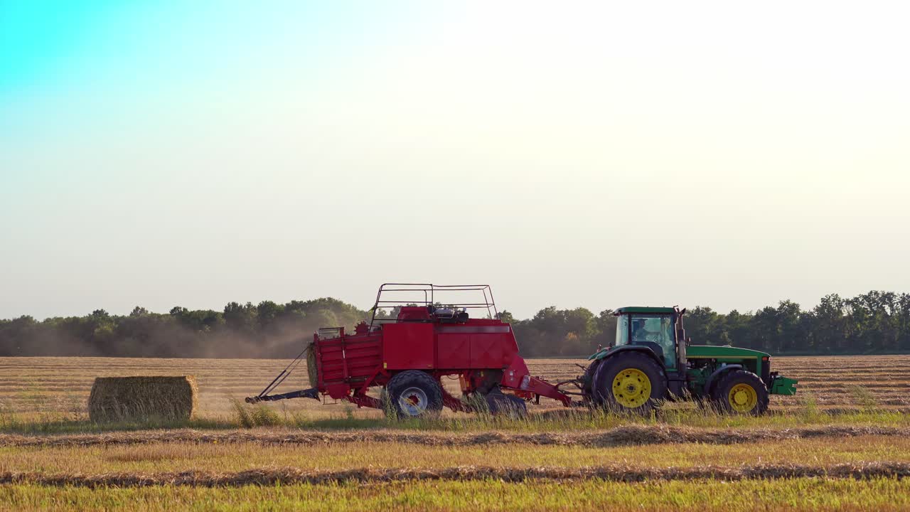 Haymaking tractor on field. Agriculture machine harvesting hay in fields