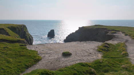 Drone-dolly-tilt-down-view-into-dramatic-Wine-Cove-on-Cornwall-coastline