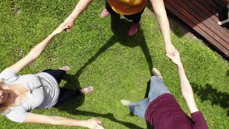 an adult man filming an aerial view of his family with a drone. his wife and children playing roundelay in their backyard during the quarantine