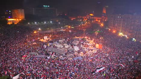 fireworks go off above protestors gathered in tahrir square in cairo egypt at a large nighttime rally 1