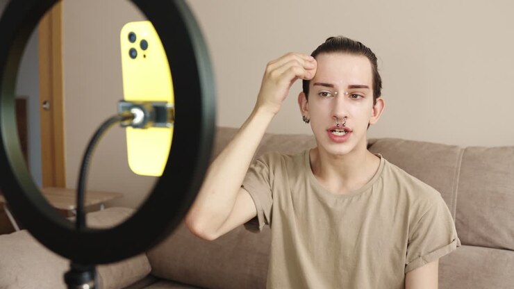 Vlogger che registra video con luce ad anello e smartphone