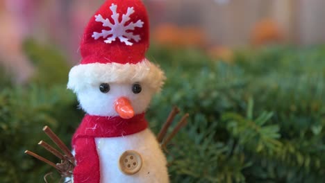 눈송이 chritsmas 테마 모자를 쓰고 있는 크리스마스 눈사람 봉제 인형 그림 장식이 선물 및 가정용품 매장에서 판매되고 있습니다.