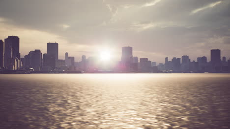 sunset over urban skyline reflecting on calm water during twilight hours