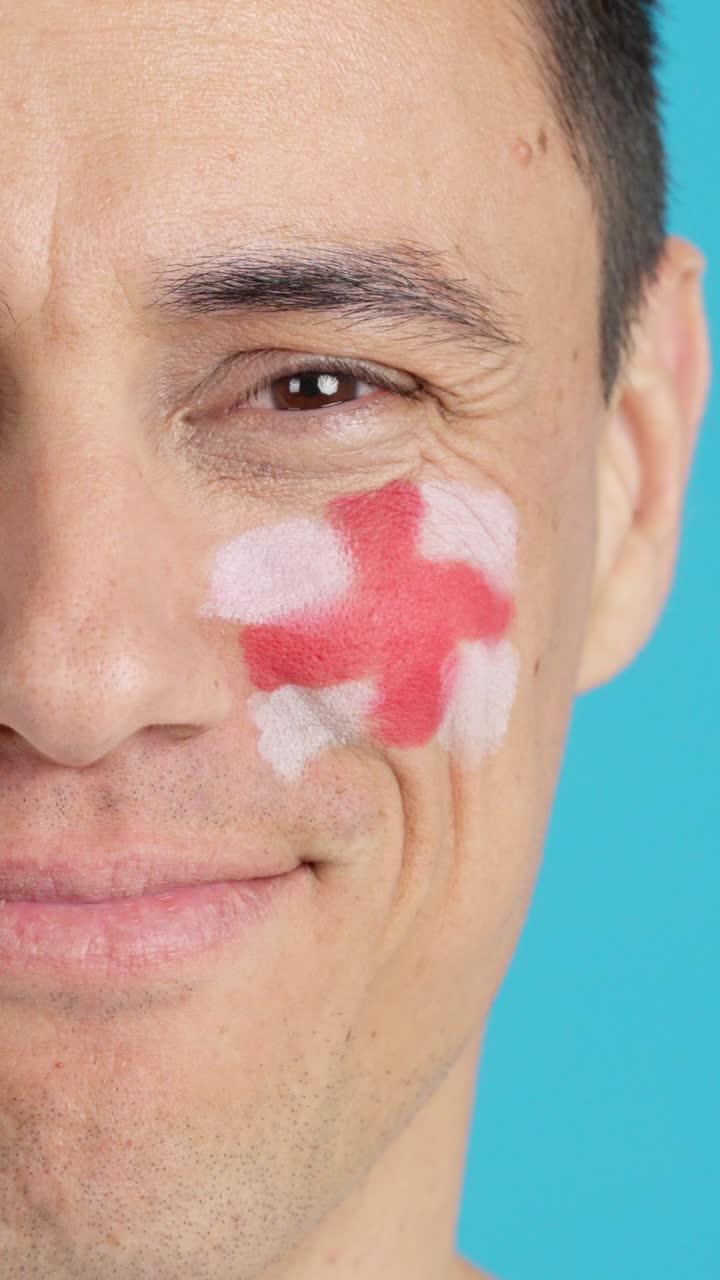Man with a english flag painted on the face smiling