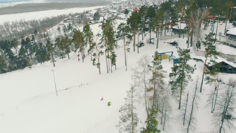 mountain slope with skiers at winter resort aerial view