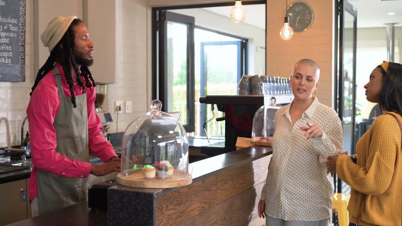 Går inn i moderne kaffebar, forskjellige venninner bestiller bakverk og betaler ved trebenk.
