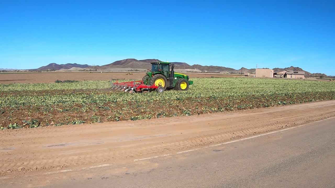 tractor tirando del arado a través de un campo cosechado – yuma arizona