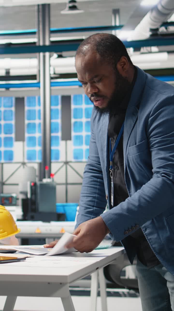 Vertical Video African american industrial expert inspecting solar panels production