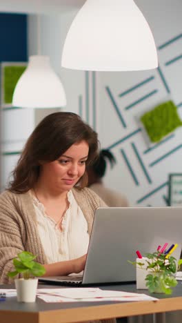 vertical video satisfied business woman answering emails typing on laptop smiling
