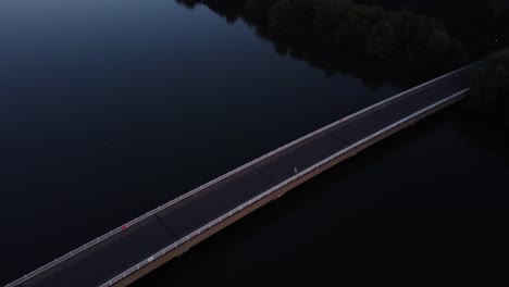 aerial view of a bridge over a lake at sunset