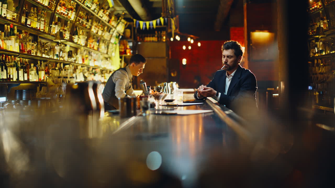 Uomo d'affari solitario che espira fumo mentre accende una sigaretta. Cliente riflessivo del bar
