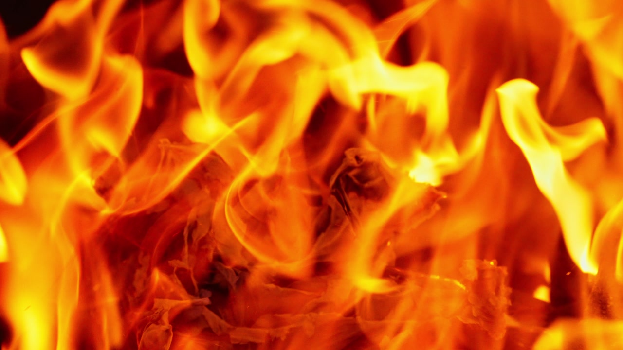 Closeup macro establishing of fire flames in motion with bright orange and red colors