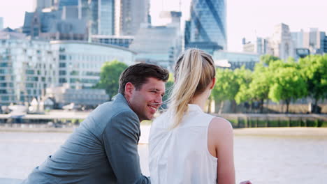 businesspeople standing by river thames and london city skyline