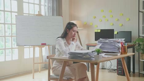 asian woman thinking and looking at paper then raising index finger while working with documents at the office