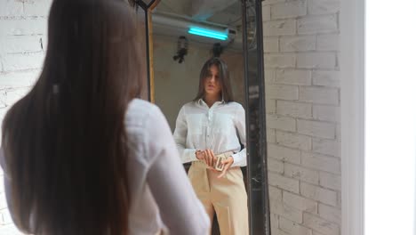 mujer probando ropa delante de un espejo