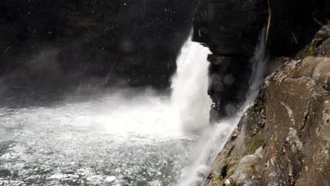 linville falls with snow falling behind the falls