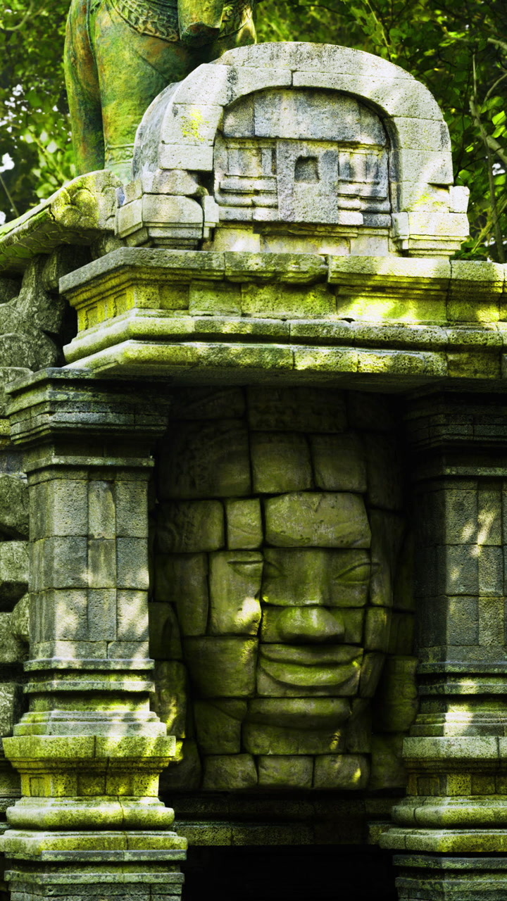 Ancient stone face hidden among lush greenery in a serene temple setting