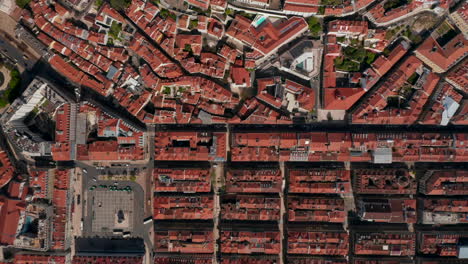 Overhead-top-down-birds-eye-aerial-view-of-patterns-of-red-rooftops-of-traditional-houses-with-narrow-streets-in-Lisbon-city-center