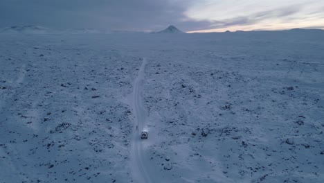 Paralaje,-Hombre-Con-Coche-Perdido-En-Medio-De-Tierra-Volcánica-Cubierta-De-Nieve.