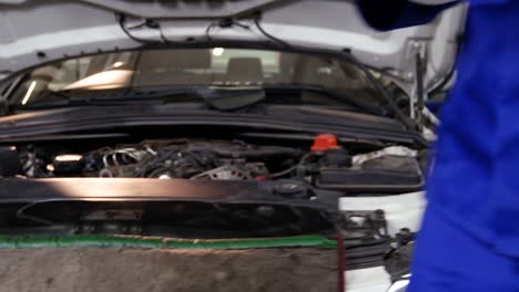 mechanic preparing a check list while servicing a car engine