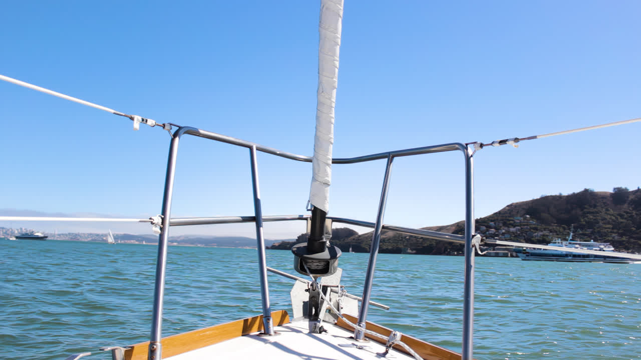 pov desde la parte delantera de un velero mientras las olas mecen el barco hacia adelante y hacia atrás en la bahía de san francisco con el puente golden gate al fondo en un día soleado en 4k