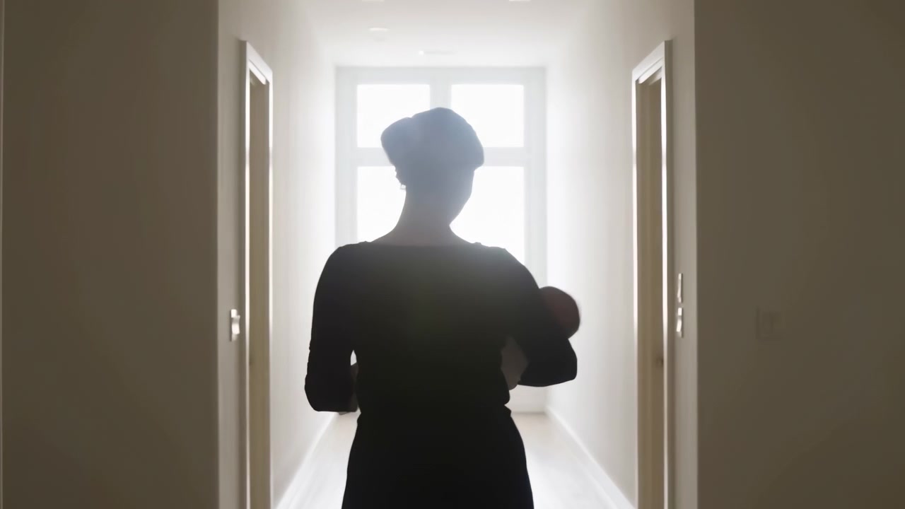 Persona in piedi in un corridoio, che guarda avanti, in un corridoio con porte su entrambi i lati, da un'angolazione fissa della telecamera da dietro la prospettiva, con oggetti vicini.
