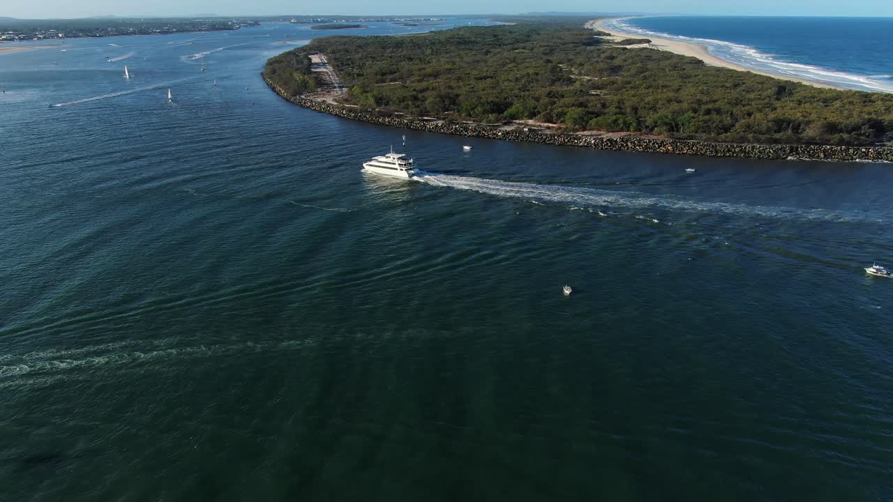 Cruise boat entering gold Coast seaway around South Stradbroke island at sunset