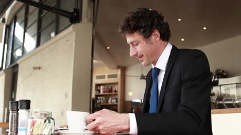 businessman ending phone call and drinking coffee