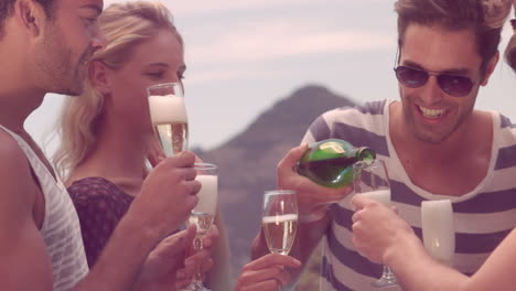 Happy-friends-celebrating-with-champagne-by-the-pool