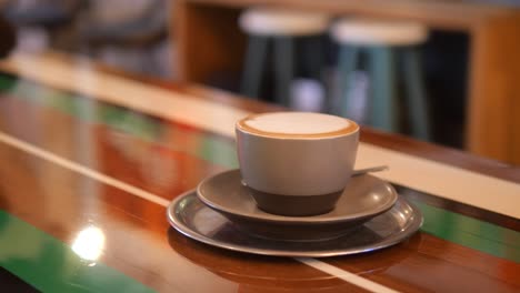 a cup of cappuccino on a wooden counter