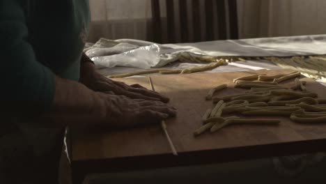 south italian old woman rolling dough to prepare traditional italian home made pasta